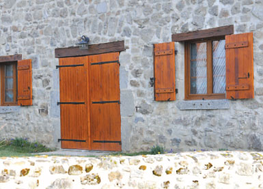 Volets battants en bois sur façade en pierre d’une maison traditionnelle