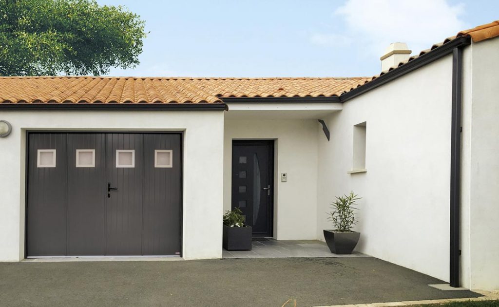 Façade de maison avec porte de garage battante grise anthracite