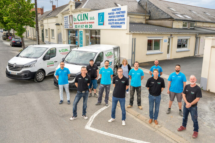 L’équipe Clin Menuiserie à Saumur devant l’atelier de menuiserie et les véhicules de chantier