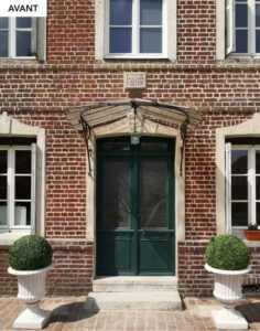 Ancienne porte d'entrée double en bois vert sur une façade en brique, avant remplacement