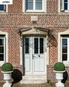 Porte d'entrée double blanche à grilles décoratives sur la même façade, après remplacement