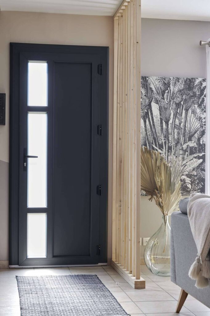 Porte d'entrée gris anthracite à vitrage latéral dépoli, vue depuis une entrée lumineuse